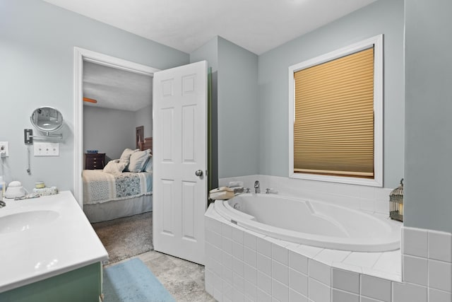 bathroom with tile patterned floors, vanity, and a relaxing tiled tub