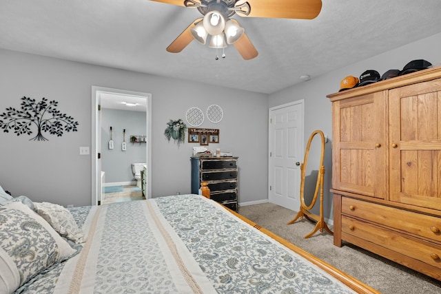 bedroom featuring ceiling fan, light colored carpet, and connected bathroom