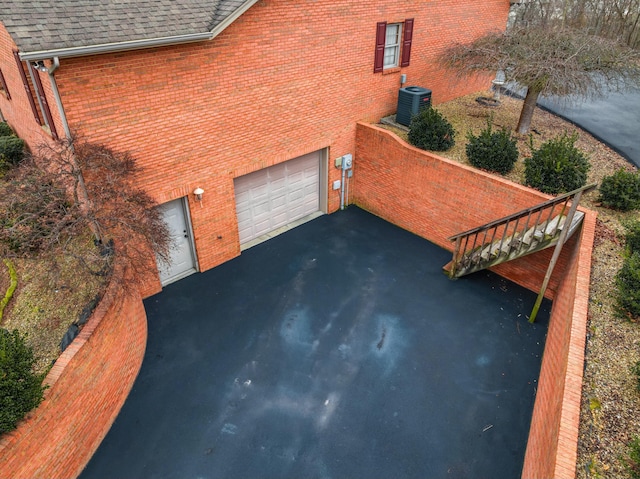 view of property exterior featuring a garage and cooling unit