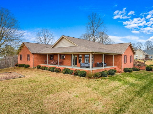 view of front of property with a front yard, an outdoor living space, and a patio