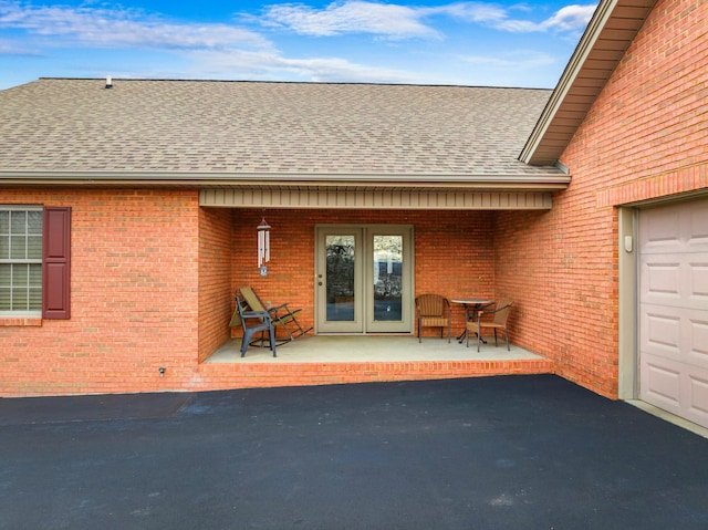 property entrance featuring a garage and a patio area