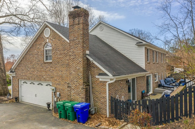 view of side of home with fence, brick siding, roof with shingles, and a chimney