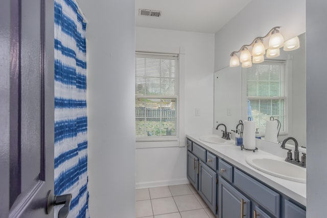 full bath featuring tile patterned flooring, visible vents, double vanity, and a sink