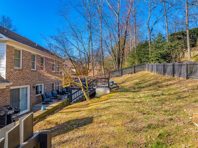 view of yard featuring a patio, a wooden deck, and a fenced backyard