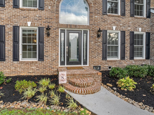 doorway to property featuring brick siding