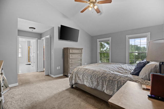 carpeted bedroom with connected bathroom, a ceiling fan, baseboards, and vaulted ceiling