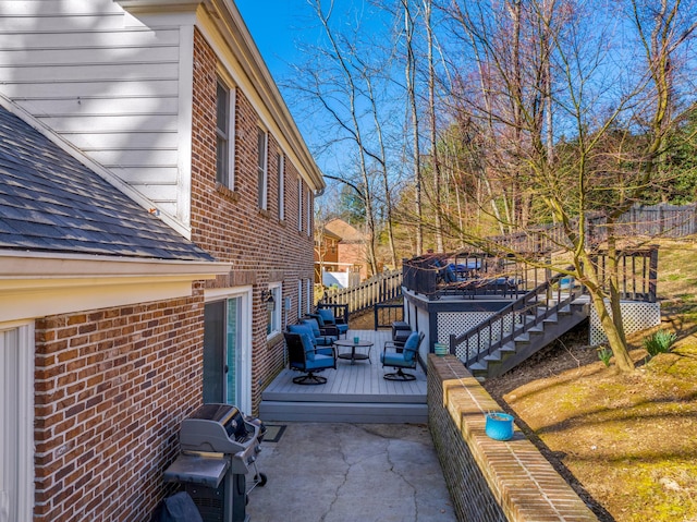 view of side of property featuring a deck, a patio, fence, roof with shingles, and brick siding