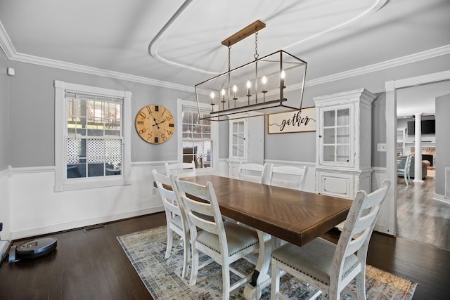 dining space featuring visible vents, a wainscoted wall, ornamental molding, and hardwood / wood-style flooring