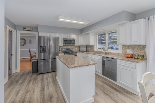 kitchen featuring a sink, stainless steel appliances, tasteful backsplash, and white cabinets