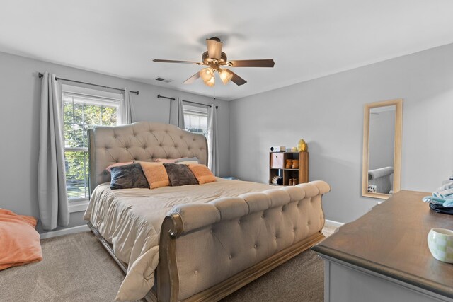 carpeted bedroom with visible vents, a ceiling fan, and baseboards