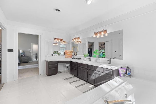 bathroom with a sink, visible vents, double vanity, and tile patterned floors