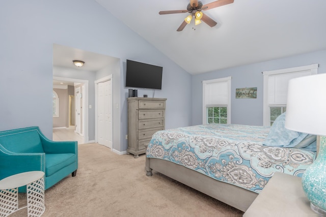 bedroom with a ceiling fan, baseboards, lofted ceiling, a closet, and light carpet