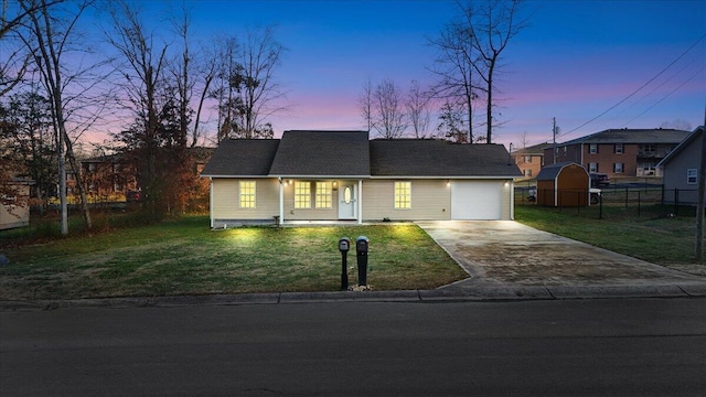 view of front facade featuring a lawn, concrete driveway, an attached garage, and fence