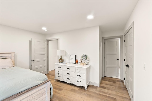 bedroom with light hardwood / wood-style flooring and a closet