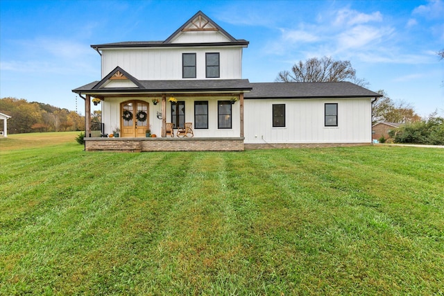 modern farmhouse with a front yard and covered porch