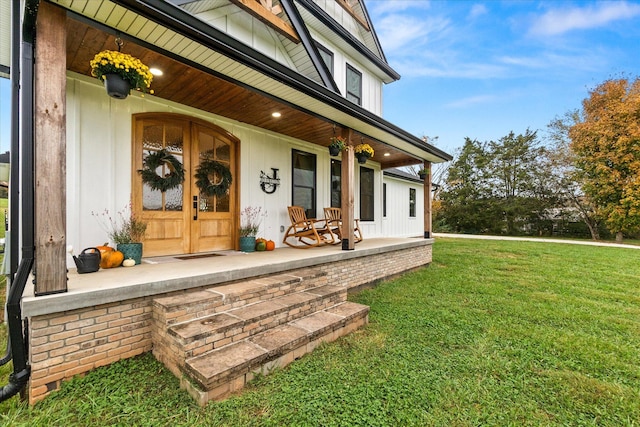 property entrance with covered porch and a yard