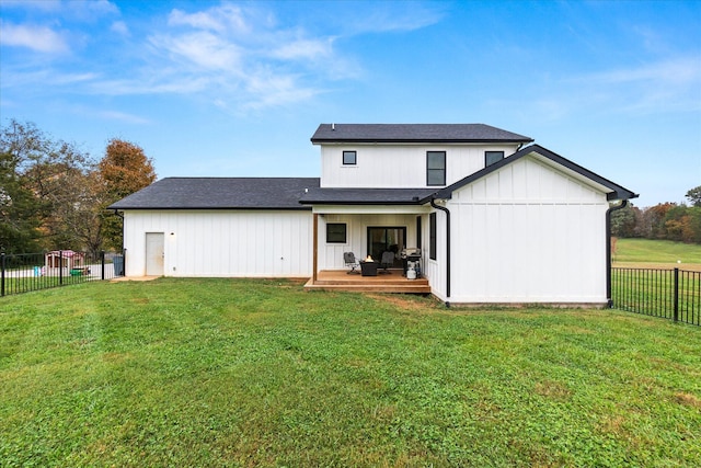 back of property with a lawn and a deck