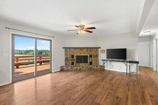 living room featuring baseboards, wood finished floors, and a ceiling fan