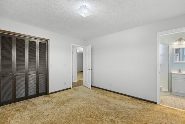 unfurnished bedroom with baseboards, a closet, light colored carpet, and a textured ceiling