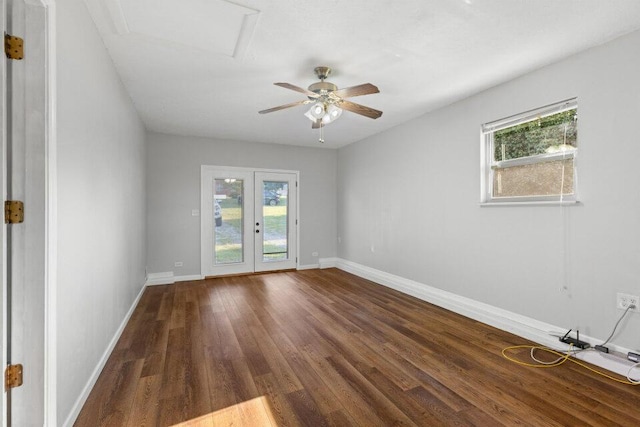spare room featuring french doors, baseboards, a healthy amount of sunlight, and wood finished floors
