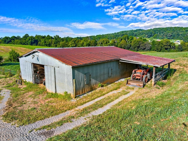 view of pole building featuring a wooded view and driveway