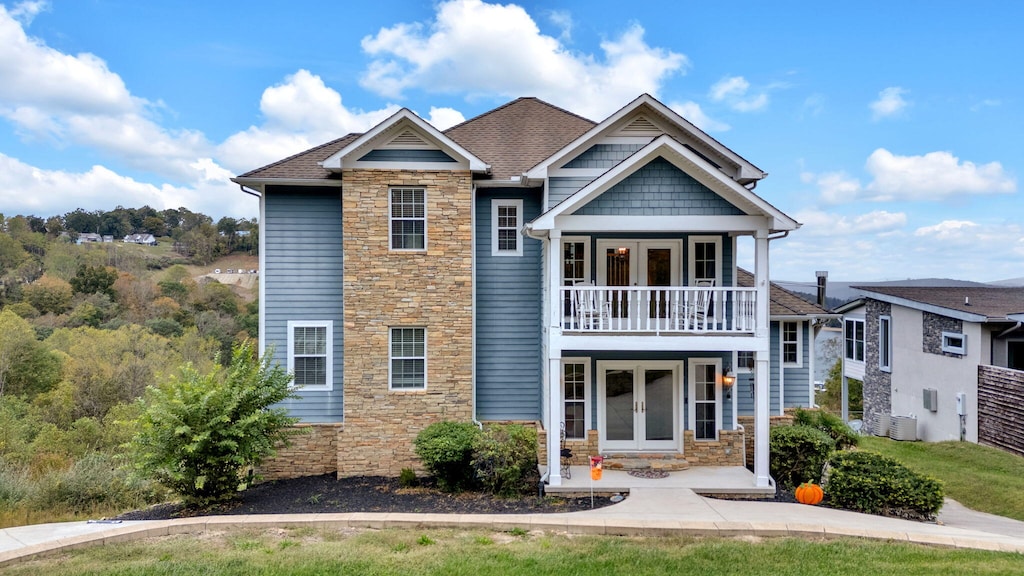 view of front of home featuring a balcony and central air condition unit