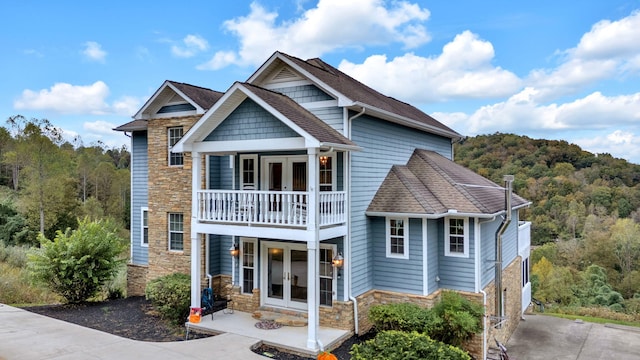 view of front of home with a balcony and french doors