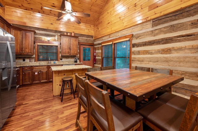 dining space featuring wood ceiling, light hardwood / wood-style floors, sink, high vaulted ceiling, and ceiling fan