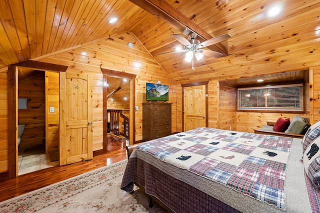 bedroom featuring ceiling fan, wooden walls, and hardwood / wood-style floors