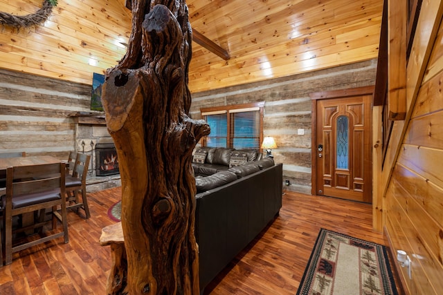 living room featuring hardwood / wood-style flooring, wood walls, vaulted ceiling with beams, and wooden ceiling