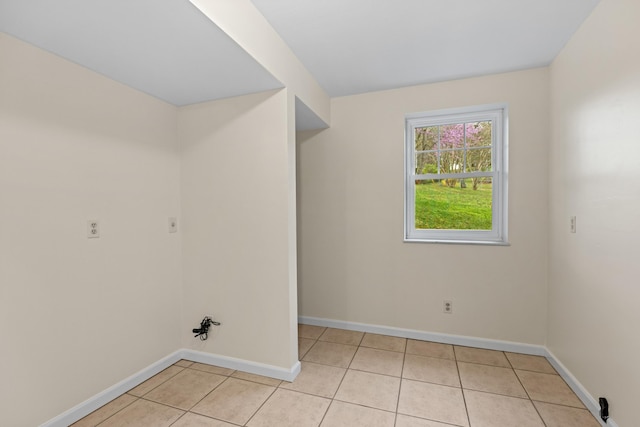 laundry room with baseboards and light tile patterned floors