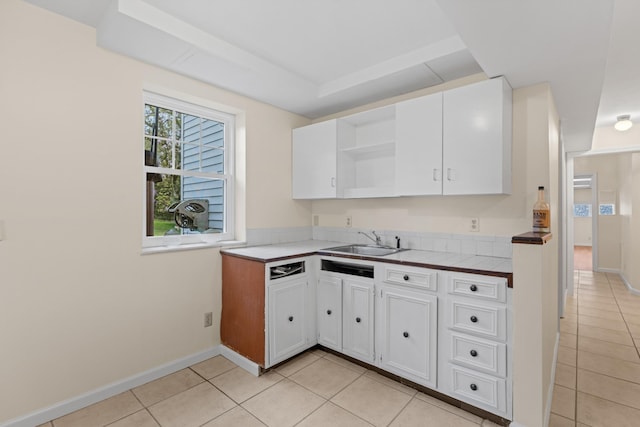 kitchen with white cabinetry, open shelves, light tile patterned floors, a sink, and tile countertops