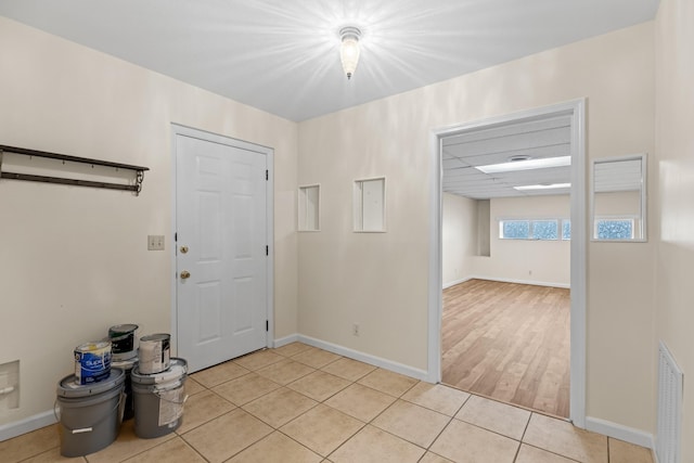 foyer entrance with baseboards, visible vents, and light tile patterned floors