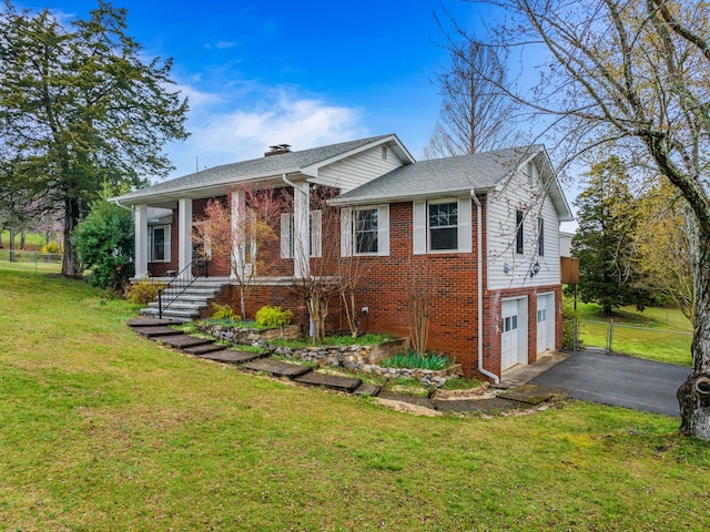 view of front of house with a front lawn, driveway, an attached garage, and brick siding