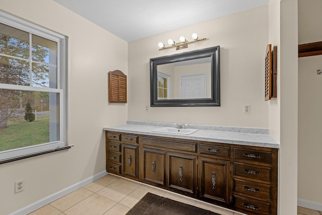 bathroom with baseboards, tile patterned flooring, and vanity