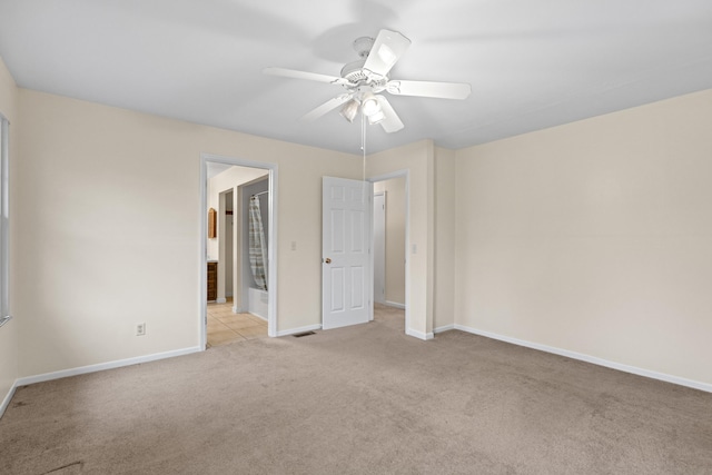 unfurnished bedroom with baseboards, carpet flooring, visible vents, and ensuite bath