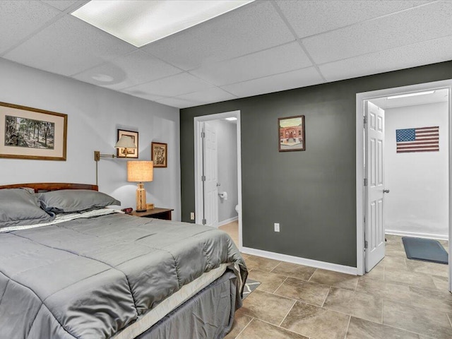 bedroom with a paneled ceiling and connected bathroom