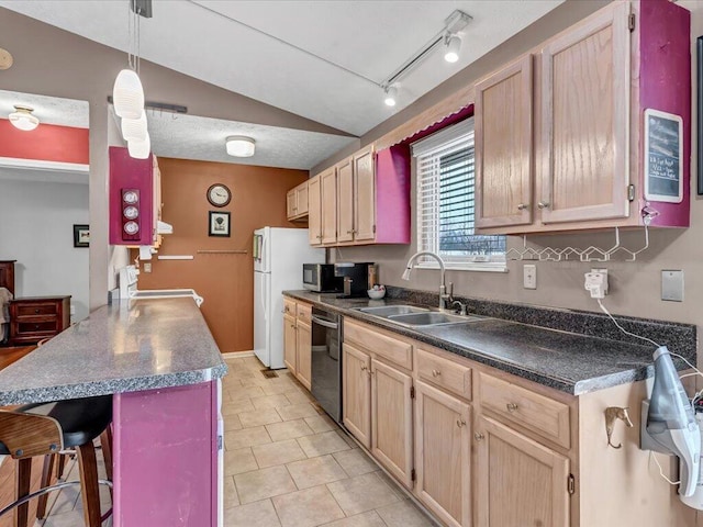 kitchen featuring vaulted ceiling, dishwasher, a kitchen bar, sink, and light brown cabinets