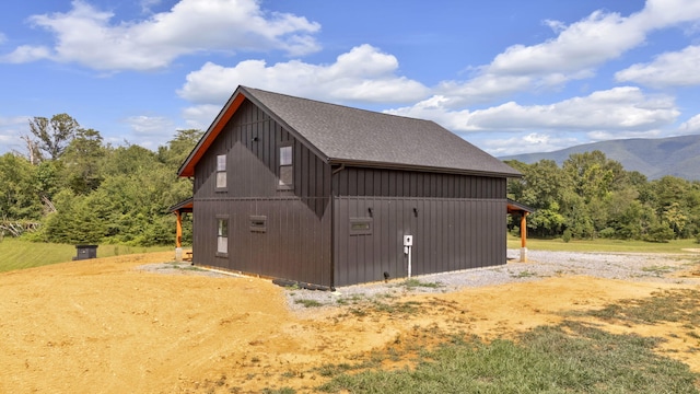 view of side of property with a mountain view and an outbuilding