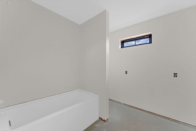 bathroom featuring a bathtub and concrete flooring