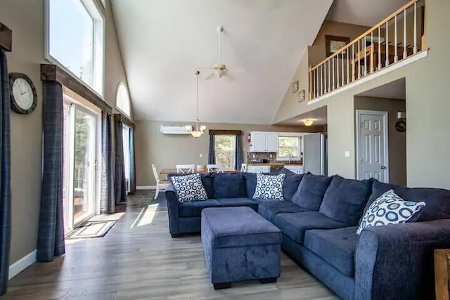 living room with hardwood / wood-style flooring, ceiling fan, and high vaulted ceiling