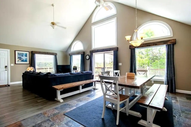 dining space with ceiling fan with notable chandelier and high vaulted ceiling