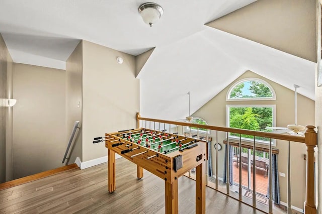 rec room featuring wood-type flooring, ceiling fan, and vaulted ceiling