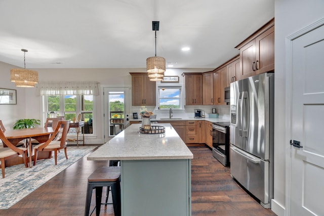 kitchen featuring stainless steel appliances, decorative backsplash, a kitchen island, a kitchen breakfast bar, and recessed lighting