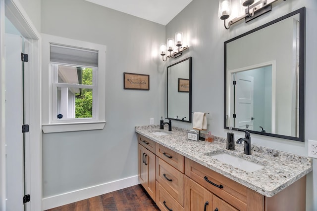 full bath featuring wood finished floors, baseboards, and double vanity