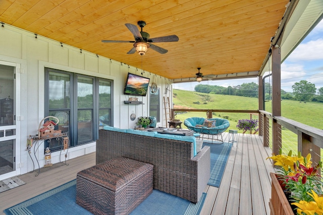 wooden terrace with an outdoor living space and ceiling fan