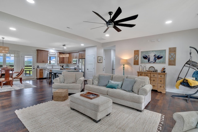 living room featuring recessed lighting, dark wood-style floors, a ceiling fan, and baseboards