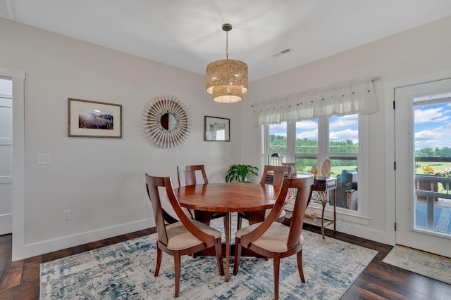 dining space with plenty of natural light, baseboards, wood finished floors, and a chandelier