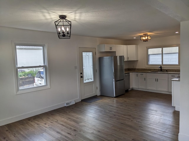 kitchen featuring freestanding refrigerator, white cabinets, visible vents, dark wood-style flooring, and a chandelier