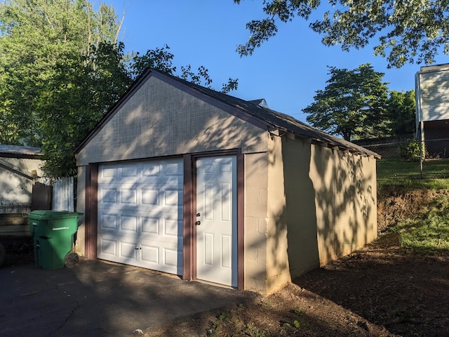 detached garage with fence and driveway